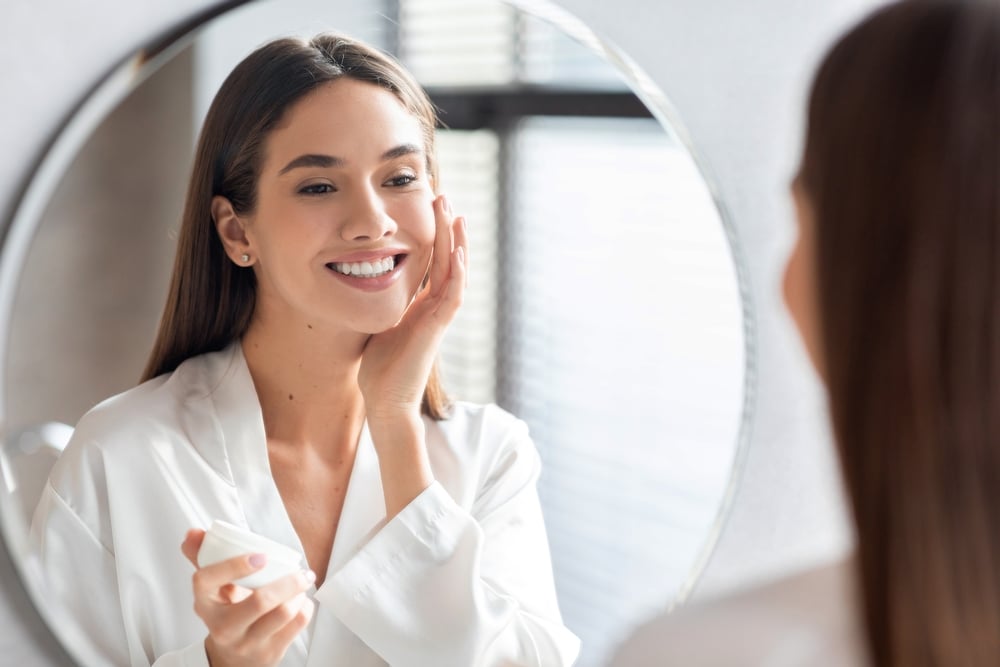 A woman looking in the mirror after an IPL treatment in Atlanta