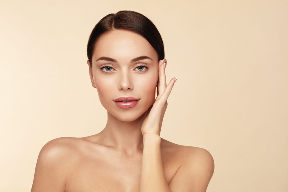 A woman touching her cheek after microneedling in Atlanta