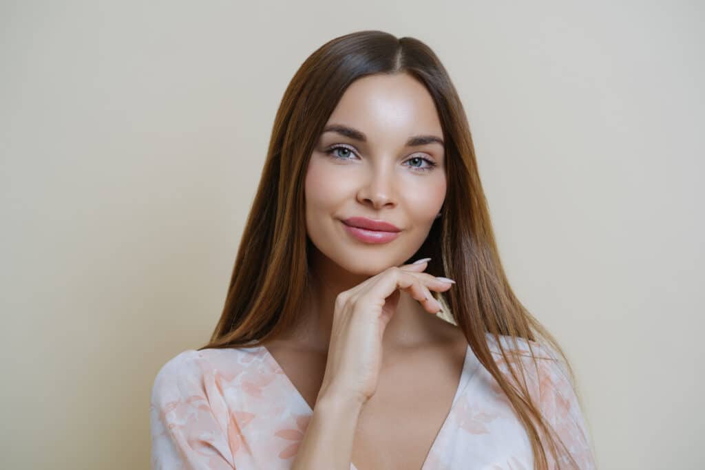 A woman smiling and showing the results of PDO threads in Alpharetta, GA