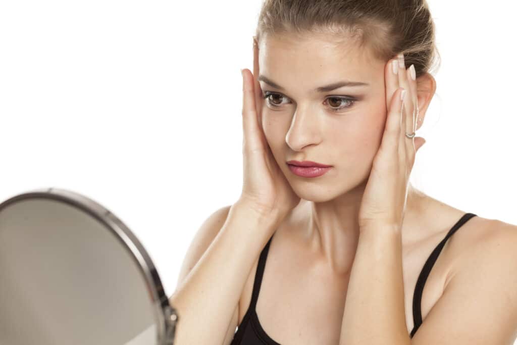 A woman looking in the mirror considering Ultherapy Prime in Atlanta, GA