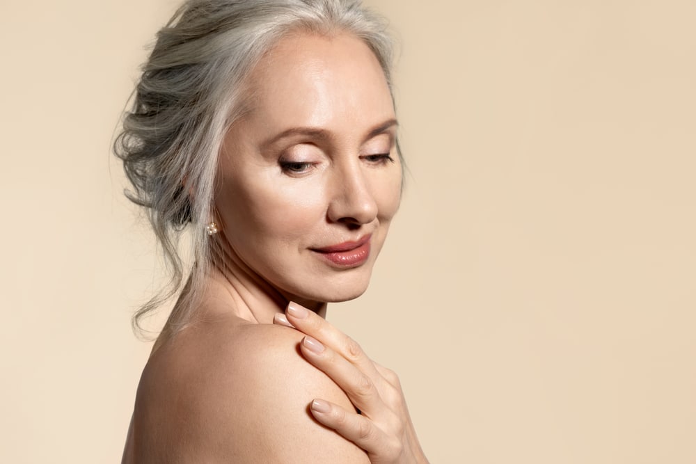 Woman looking over her shoulder showing results of copper peptide therapy Woman looking over her shoulder showing results of copper peptide therapy